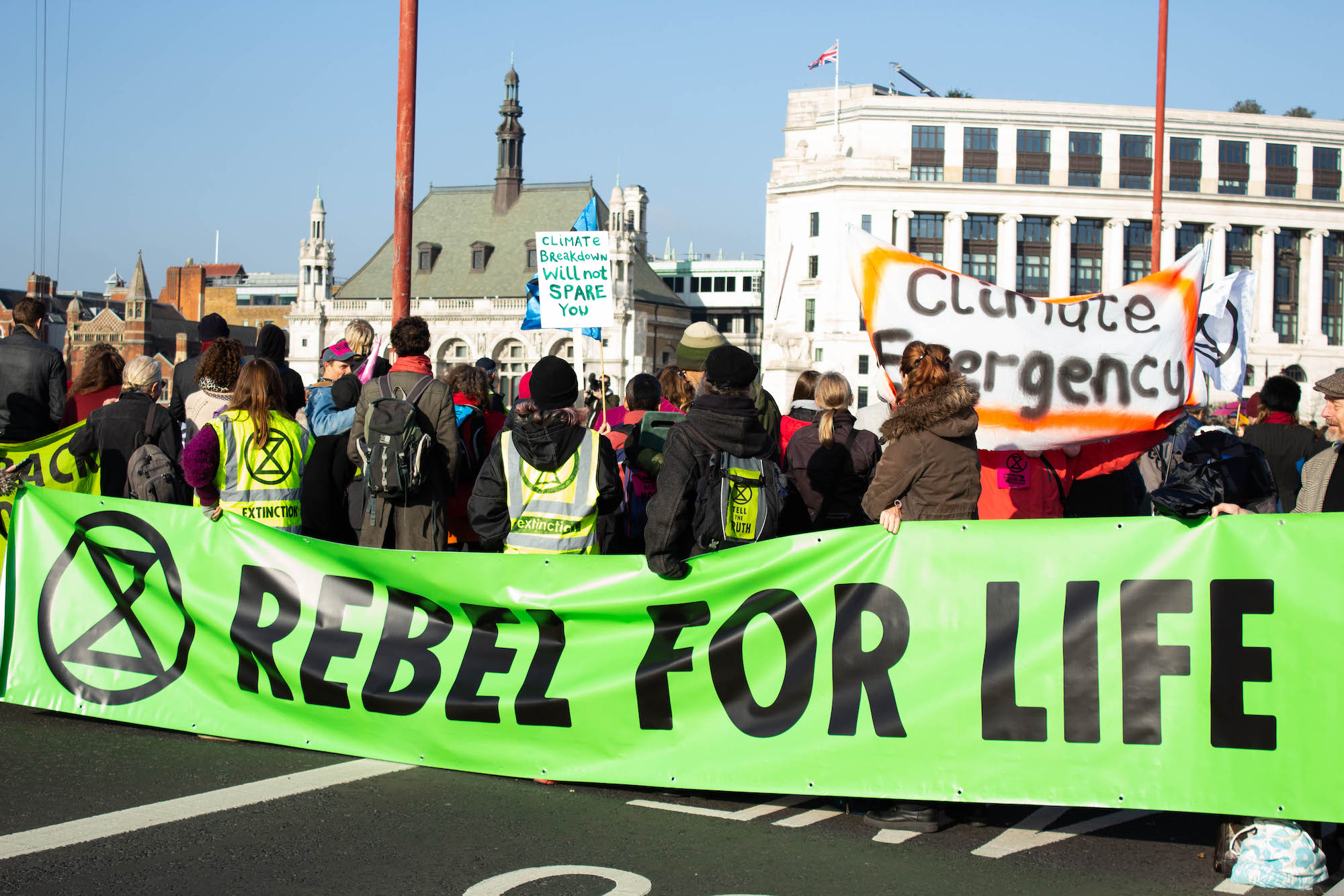 Extinction Rebellion protestors with a large banner proclaiming 'Rebel for Life'